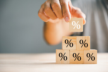 Illustrating the concept of interest rate and financial ranking. Businessman's hand placing a...