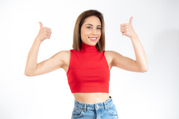 Fototapeta na wymiar Smiling pretty young woman showing thumbs up isolated over white background