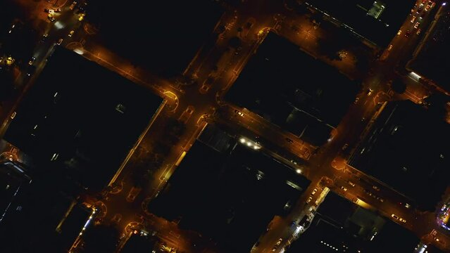 Drone of cars, road and city background at night for travel, street grid infrastructure and transport with aerial view of rooftop. Buildings, lights and cityscape of neighborhood or dark architecture