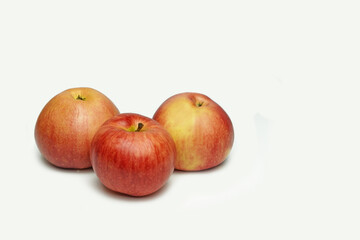 Fototapeta na wymiar Three natural ripe apples, red and yellow, on a white, isolated background.
