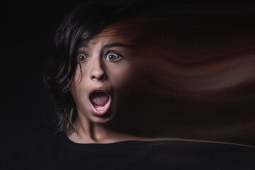 Portrait of a scared teenage girl losing her identity with her face dissolving into a trail of dust