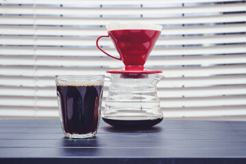 Pouring coffee into a glass on the table