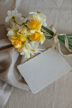 Overhead view of a bunch of daffodils with a blank card on a table