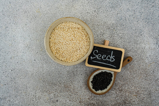 Overhead view of organic black and white sesame seeds with a seeds sign