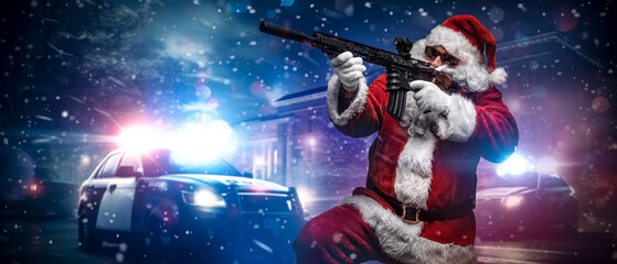 A man dressed as Santa Claus, holding a machine gun, poses in front of police cars with numerous...
