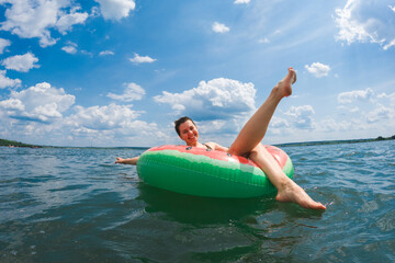 happy woman chilling on inflatable pool floats