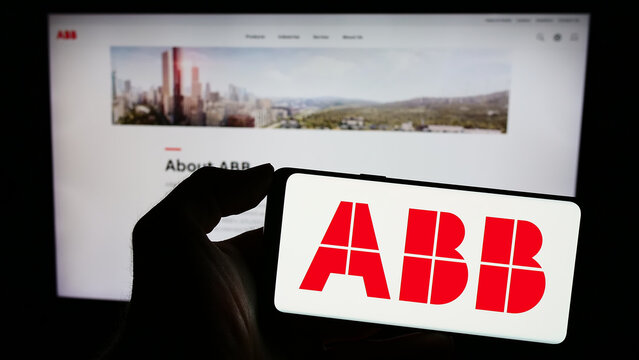 Stuttgart, Germany - 11-16-2023: Person holding smartphone with logo of electrical equipment company ABB Ltd. in front of website. Focus on phone display.