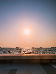 Esplanade and Aegean Sea at sunset with cargo ships in the distance