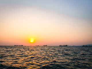 Cargo ships on the Aegean Sea during sunset with clear sky