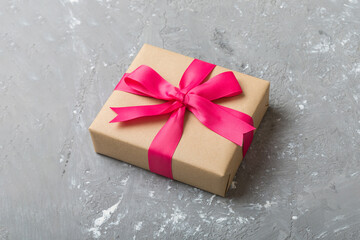 Wrapped christmas or other holiday handmade present in craft paper with colored ribbon. Present...