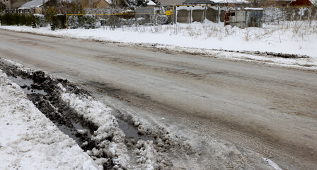 Snowy road in countryside. Drifts on an unplowed snow-covered country road through cottage...