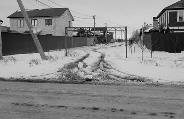 Snowy road in countryside. Drifts on an unplowed snow-covered country road through cottage...
