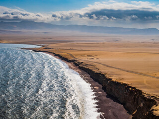 Panoramic view of the desert in Paracas National Reserve with the famous Red Beach in foreground, Ica region, Peru