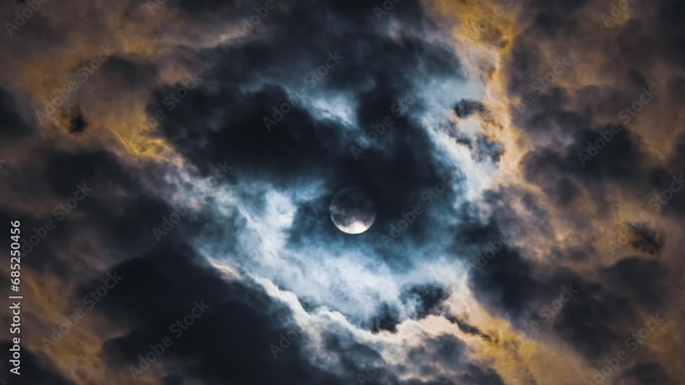 Wall mural time lapse of full moon in the clouds. clouds look like smoke from a fire. black and yellow colours.