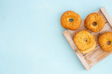 Set of fresh bread bagels on wooden board, top view