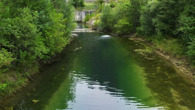 A drone soars above a canalization canal with water bubbling
