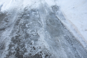 Iced road in winter. Dangerous seasonal road conditions. Horizontal format.