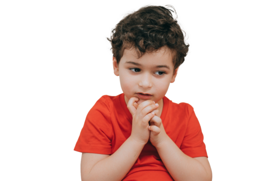 Little pensive curly boy makes decision being in doubts, has hesitation stands against transparent background with copy space.