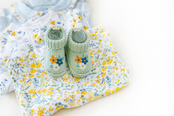 Handmade knitted booties, organic cotton baby clothes with copy space. Baby fashion, trend. Pregnancy and motherhood concept