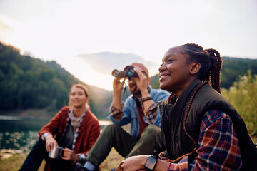 Happy black woman enjoys with her friends in nature.