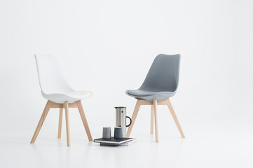 Two modern chairs with a serving of coffee