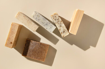 Natural herbal beige and brown soap bars on light beige top view, hard shadows