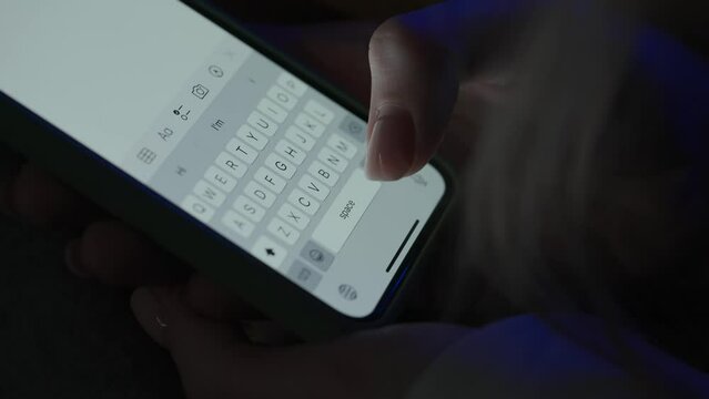 Text message with mobile phone. Woman texting sms with smartphone. Catfish or digital scam. Screen keyboard in instant messaging chat. Macro shot of finger writing.