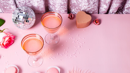Two retro glasses with pink cocktail in a festive pink atmosphere, concept for Valentine's day,...