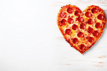 pepperoni pizza in form of heart for valentines day on white wooden background with copy space. Top view