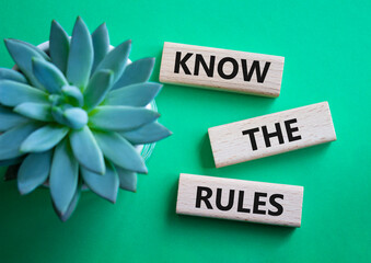 Know the rules symbol. Wooden blocks with words Know the rules. Businessman hand. Beautiful green...