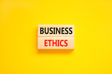 Business ethics symbol. Concept words Business ethics on beautiful wooden blocks. Beautiful yellow table yellow background. Business ethics concept. Copy space.