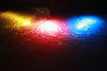 Yellow, red and blue lanterns underwater in a fountain