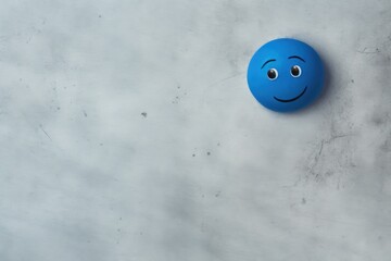 A blue ball with a smiley face on it. Can be used to represent happiness and positivity in various contexts.