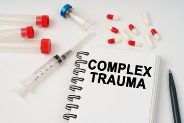 On the table are pills, injections, a syringe and a notepad with the inscription - complex trauma