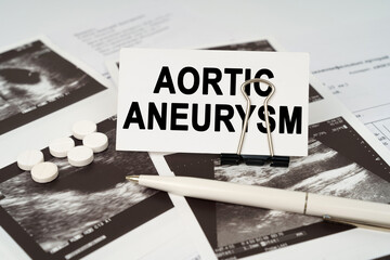 On the ultrasound pictures there is a pen and a business card with the inscription - Aortic aneurysm
