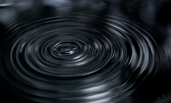 Ripple of water or water drop splash on black background. Abstract shape out of the water