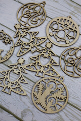 Set of flat wooden toys for the Christmas tree lies on a white wooden background