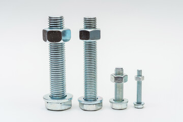 group of bolts and nuts on a white background. bolts, washers and nuts assembled on a light background. photo of fasteners with threads for the catalog