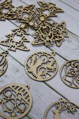 Set of flat wooden toys for decorating the Christmas tree for the New Year lies on a white table