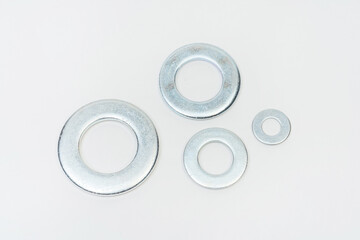 washer on a white background. metal flat on a light background. photos of fender for bolts for the...