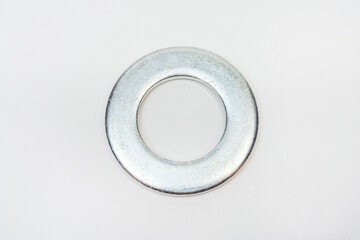 washer on a white background. metal flat on a light background. photos of fender for bolts for the catalog