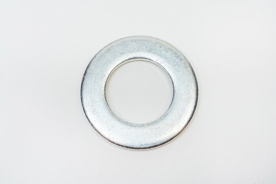 washer on a white background. metal flat on a light background. photos of fender for bolts for the catalog