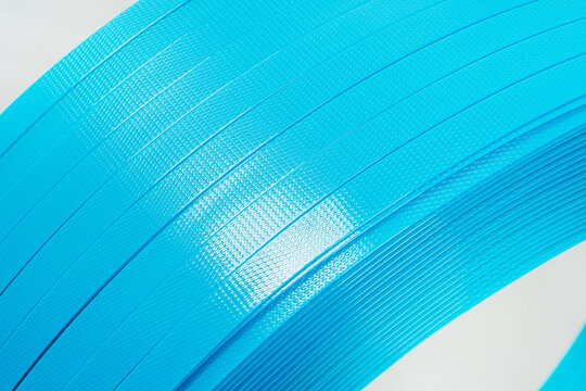 blue polyester tape on a white background. high-strength temoplastic tape in a roll on a light background. tape packaging material in roll