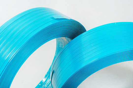 blue polyester tape on a white background. high-strength temoplastic tape in a roll on a light background. tape packaging material in roll