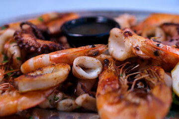Fried shrimp, octopus and other seafood on a plate. Isolated over white background