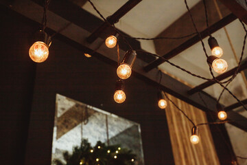 retro bulb hanging decoration for design purpose.Garland of Edison bulbs hanging on laces.garlands on the ceiling, interior and design concept. architectural lighting of the room in a retro style