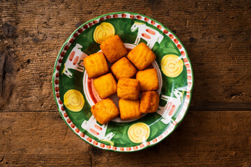 top view plate with mozzarella in carrozza, italian gastronomic specialty, wooden background