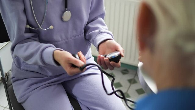 
The nurse carefully measures the blood pressure of an elderly person using a specialized device. A moment of care and medical attention in the senior years
