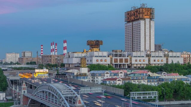 Evening view at the Russian Academy of Sciences day to night transition timelapse and Novoandreevsky Bridge over the Moscow River. Aerial view from rooftop after sunset