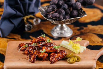 Crispy Fried Chicken Wings with sauce served on wooden board isolated on table side view of arabic appetizer food